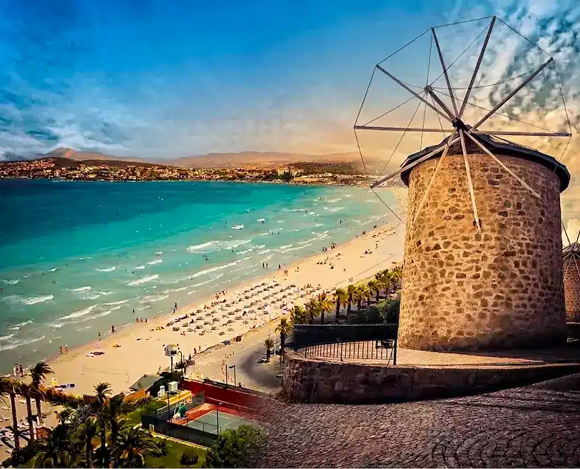 İzmir Havalimanı transferiyle ulaşılan Çeşme Ilıca Plajı ve Alaçatı yel değirmenlerinin bir arada göründüğü manzara